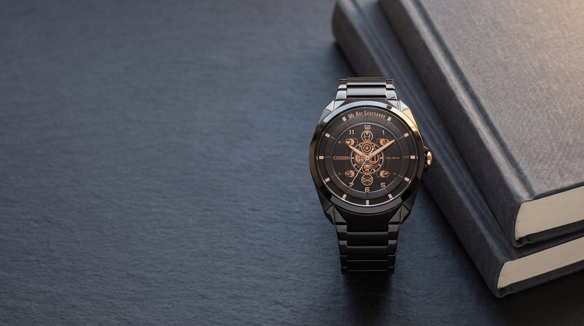 Citizen Marvel 85th anniversary watch on dark slate beside two books